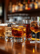© SashaMagic - Assorted cocktails on a bar counter with a blurred background.
