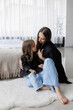 © Vasil - Mother and daughter share a loving moment in a cozy modern living space