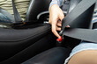 © Natee Meepian - Safety first: woman buckling seatbelt in car