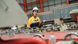© AU USAnakul - Female industrial engineer evaluates roll forming machine inside a steel roofing sheet production plant. Holding a clipboard, she checks machine alignment and process readiness for quality control.