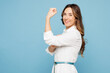 © ViDi Studio - Young successful employee business woman corporate lawyer in shirt classic formal clothes work in office showing biceps muscles on hand demonstrating strength power isolated on blue color background