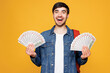 © ViDi Studio - Young surprised boy student he wears denim casual clothes backpack bag hold in hand fan of cash money in dollar banknotes isolated on plain yellow background. High school university college concept.