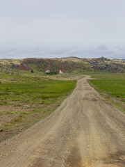 Wall Mural - Dirt road with small building in rural Iceland.