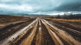Muddy path in a mountain area with aggressive off-road tire marks and splattered mud all around