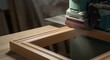 © Nurul - Wood Frame Being Sanded with Teal Drum Sander in Workshop