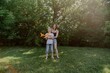 © looking2thesky - A mother and her son with hearing aids launch a paper airplane in a park, a heartwarming moment of inclusive play and bonding in nature. Perfect for disability awareness and family lifestyle content