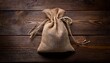 © Arnold - burlap sack with tied string sits centered on dark rustic wooden planks