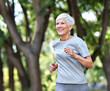 © Lumos sp - Smiling active mature elderly woman jogging running in the park