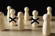 © New Africa - Dismissal. Two human figures with black crosses among others on wooden table