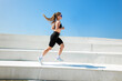 © muse studio - Energetic runner conquering outdoor stairs in sunny urban landscape