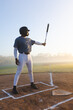 © Wavebreak Media - Metal bat resting horizontally in chalked batter's box on dirt infield, under misty golden sky
