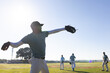 © Wavebreak Media - Diverse male teammates practicing throwing and fielding on baseball field with gloves, copy space