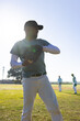 © Wavebreak Media - African American male athlete winding up to throw ball with glove on baseball field in sunlight