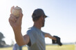 © Wavebreak Media - Man holding baseball wearing black glove while standing on baseball field in dark cap, copy space