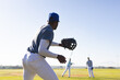 © Wavebreak Media - Diverse male baseball players fielding ground ball on grassy baseball field with caps and gloves