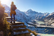 © Jakub - Hiker girl climbs snow-covered stairs on Sealy Tarns Track, admiring alpine views of Aoraki Mount Cook and surrounding glacial lakes, South Island, New Zealand