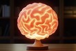 © Andi - Illuminated brain-shaped lamp on a wooden base.