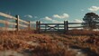 © Oulaphone - A rustic wooden fence and gate surround a grassy field, with a tree and cloudy blue sky in the background, evoking a peaceful countryside scene.