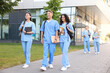 © New Africa - Medical students in uniforms walking near building outdoors