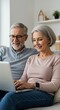 © Pix - Happy Elderly Couple Enjoying Technology And Using A Laptop Together Indoors