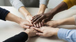 © Image Archives - Real human hands coming together over wood table symbolizing teamwork, unity, support and collaboration in diverse professional setting