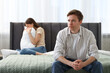 © New Africa - Woman and man having quarrel on bed at home, selective focus