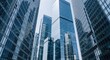 © Farhan - A low-angle, powerful view of modern glass skyscrapers in a major financial hub. A symbol of corporate power, finance, and urban architecture.
