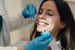© Zamrznuti tonovi - Dentist examining teeth of smiling female patient in dental clinic