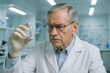 © Mostafizur - Senior laboratory professional analyzing a vial of clear liquid in a high tech scientific lab, depicting the process of innovation and discovery
