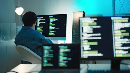 programmer coding software using multiple screens in modern workspace, working on cybersecurity, dat