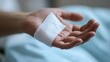 © KimMi - A close-up of a hand with a fresh white bandage after minor surgery in a hospital
