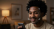 © abu - Smiling African American Man Holds Smartphone with Facial Recognition Mapping Dots in Soft Lit Living Room with Sofa