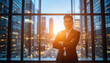 © RUHAN - Confident young businessman standing tall with arms crossed overlooking city skyline at sunset, embodying leadership and success with modern professional style