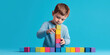 © Anastasia - The child builds a tower of wooden colored cubes, concentrates intensely.