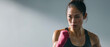 © DOUGLAS - Asian female athlete shadowboxing focused determined pink hand wrap gym fitness strength