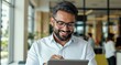 © mlangsen - Smiling man uses tablet in bright office setting