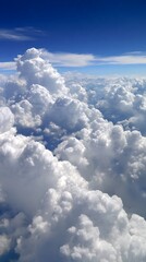 Wall Mural - aerial view of fluffy cumulus clouds against a deep blue sky on sunny day