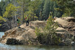 © Mediaphotos - Group of young adult multiethnic men and women standing on rocky hill near water, wearing safety vests cleaning nature during volunteer event
