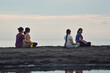 © agratitudesign - While sitting cross-legged on the beach, one of the girls provides subtle guidance as they prepare for the next phase of their relaxing yoga sequence.