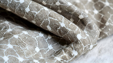 Soft, wrinkled fabric with a subtle floral print in muted taupe and white.  Close-up view of the textile's texture and pattern