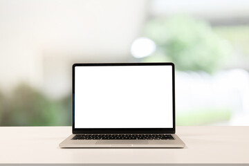 close up blank white screen display of laptop computer on table in office building with garden scene