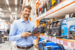 © ty - Portrait of happy man using digital tablet in hardware store