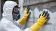 © Rafay - Protective gear and safety precautions person in hazmat suit inspects brick wall surface area