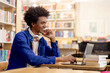 © Home-stock - Happy smart black student guy using laptop for online lesson in library, showing modern approach to education, free space