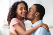 © Prostock-studio - Handsome black father kissing his cute little daughter, closeup portrait, home interior. Adorable african american girl spending weekend with her loving dad, standing in kitchen and bonding
