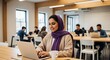 © Cuan - A young woman in a hijab works diligently on her laptop in a modern, bright coworking space, surrounded by other professionals.