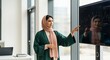 © Cuan - A Muslim businesswoman in a hijab confidently interacts with a large touchscreen display showcasing financial data.