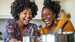 © nara - Happy women cooking together in kitchen, laughing