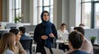 © Fajar - A young woman in a hijab confidently leads a diverse team meeting in a modern, open-plan .