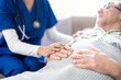 © NAMPIX - Cropped shot of trust doctor or nurse holding patient hands for help, consulting support and healthcare advice, counseling and medical therapy in nursing home